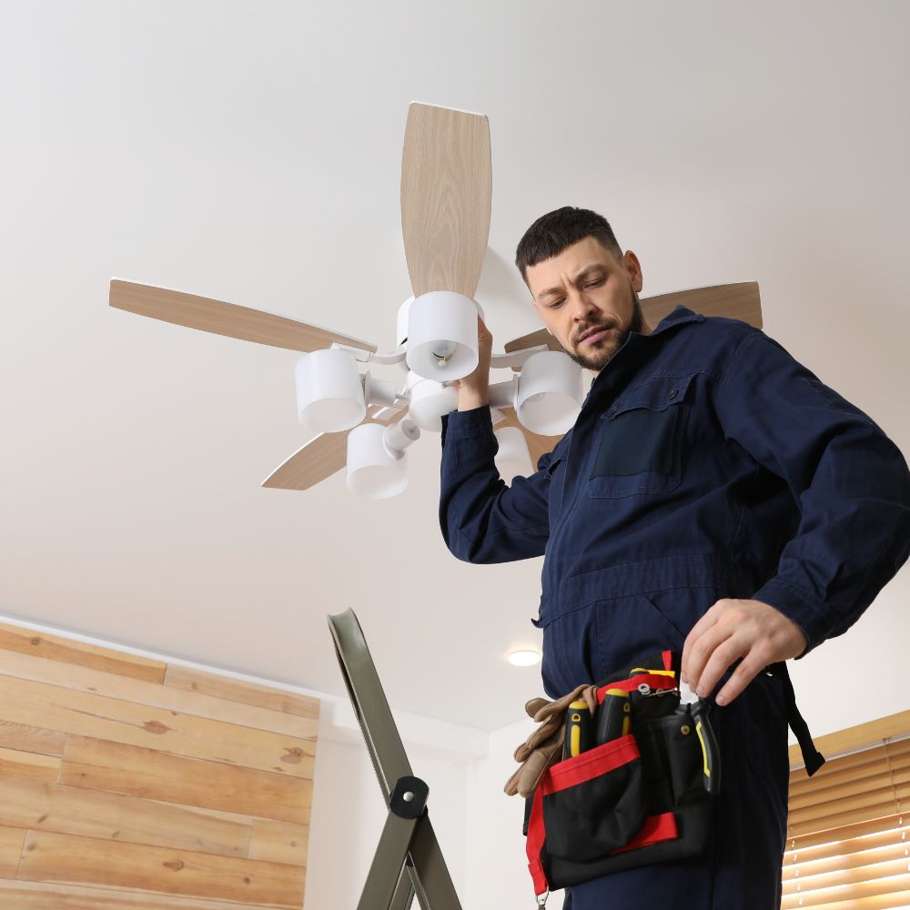 An electrician installing a ceiling fan.